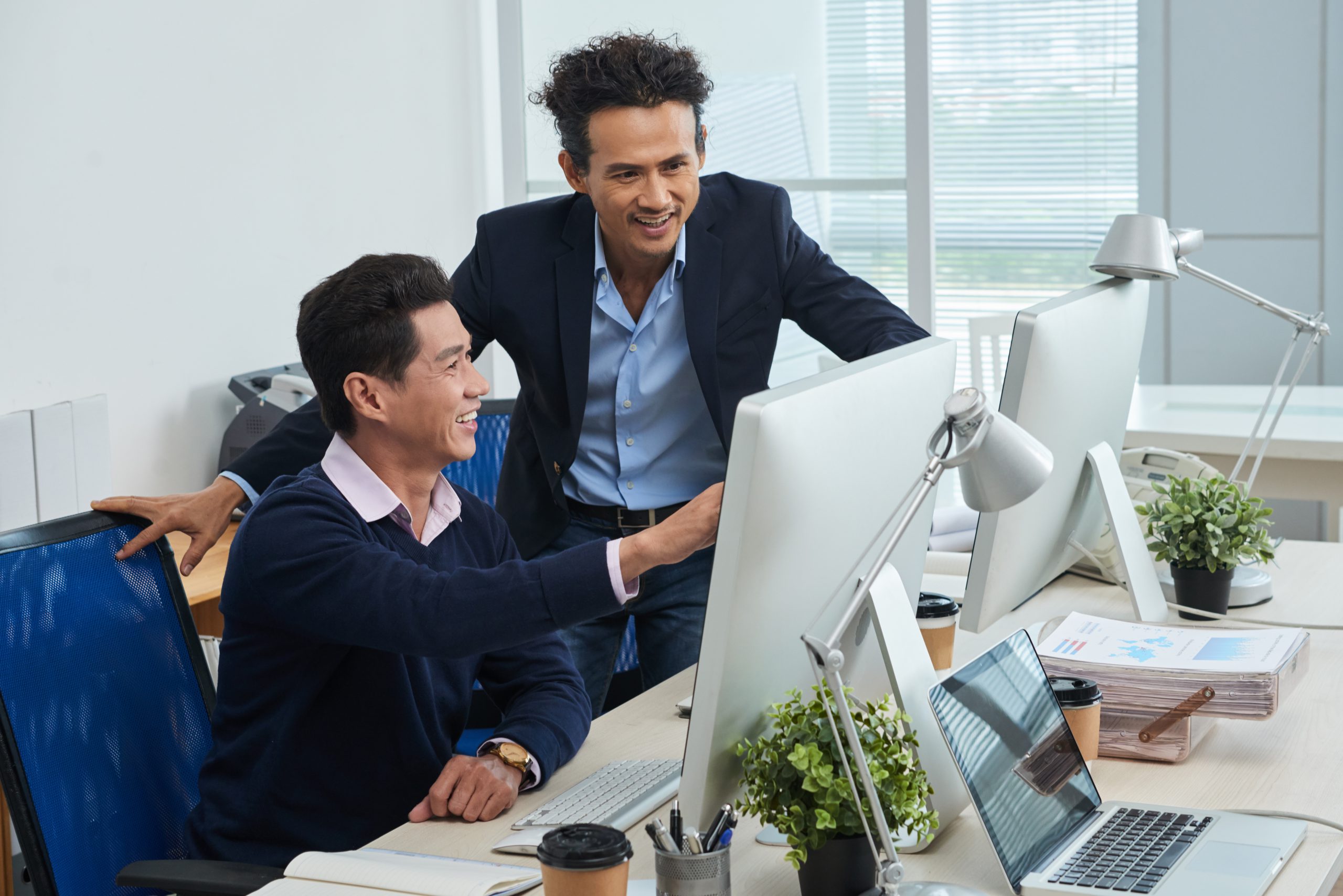 2 working males discussing in office